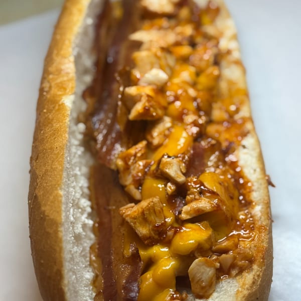Joe Beez deli sandwich with chicken, melted cheese, and sauce in a toasted bun.