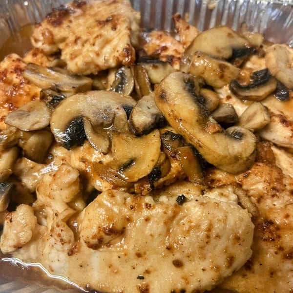 Joe Beez deli's chicken and mushrooms, glistening with sauce in a foil container.
