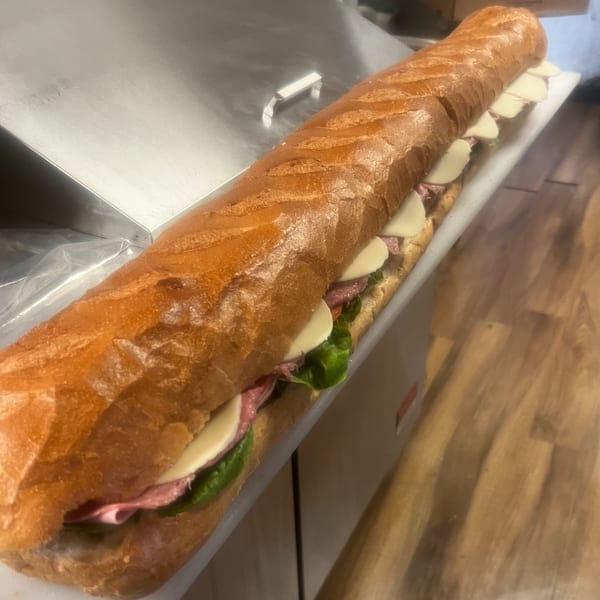A long deli sub sandwich from Joe Beez, filled with meat, cheese, and lettuce.